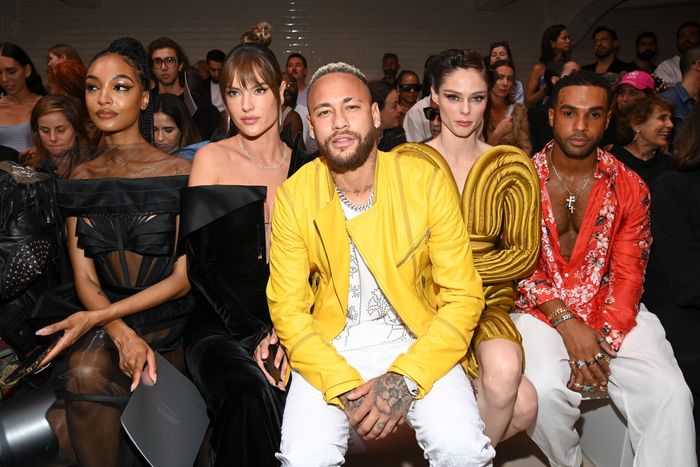  Ngồi giữa Alessandra Ambrosio và Coco Rocha, Neymar xuất hiện nổi bật tại hàng ghế đầu trong show của Jean-Paul Gaultier. Nam cầu thủ diện thiết kế màu vàng nổi bật. Anh phối mẫu áo khoác cùng trang phục tông trắng để tạo tổng thể hài hòa. Công thức phối đồ này an toàn, giúp ngoại hình của Neymar thời thượng, sành điệu. Ảnh: Just Jared. 